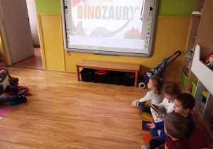 przedszkolaki oglądają prezentację o dinozaurach